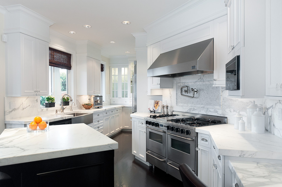 Photo of a traditional galley separate kitchen in Vancouver with a farmhouse sink, recessed-panel cabinets, white cabinets, marble benchtops, white splashback and stone slab splashback.