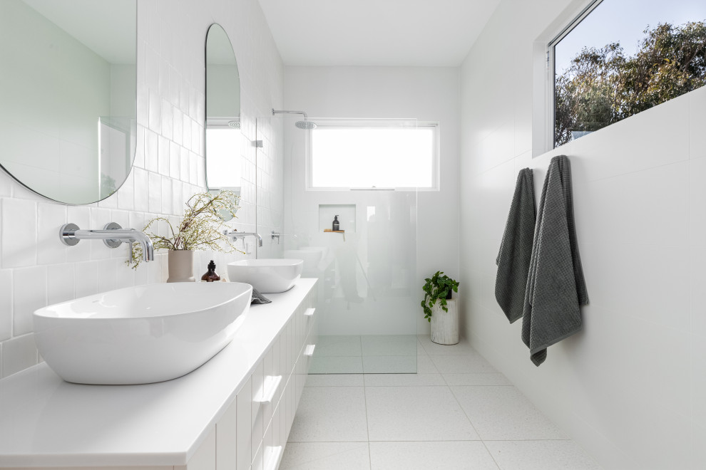 Inspiration for a beach style bathroom in Sydney with flat-panel cabinets, white cabinets, a curbless shower, white tile, a vessel sink, white floor, an open shower, white benchtops, a niche and a double vanity.