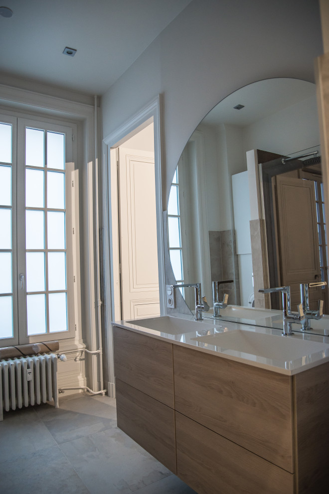 This is an example of a transitional bathroom in Saint-Etienne with beaded inset cabinets, beige cabinets, a curbless shower, a wall-mount toilet, multi-coloured tile, slate, beige walls, ceramic floors, a console sink, laminate benchtops, grey floor, an open shower, white benchtops, a double vanity and a floating vanity.