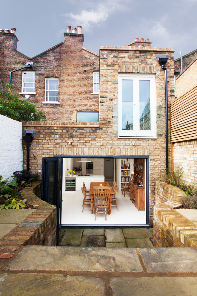This is an example of a mid-sized traditional three-storey brick brown exterior in London.