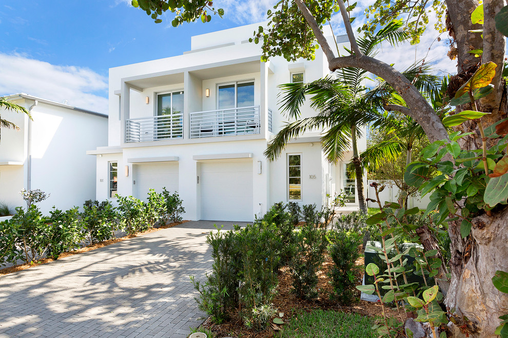 Photo of a large modern three-storey concrete white duplex exterior in Miami with a flat roof.