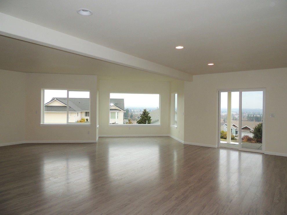Example of a huge transitional walk-out laminate floor and gray floor home design design in Seattle with beige walls