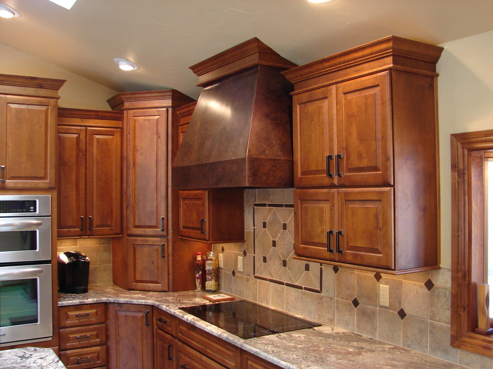 Example of a transitional l-shaped eat-in kitchen design in Denver with raised-panel cabinets, medium tone wood cabinets, granite countertops, beige backsplash, porcelain backsplash and stainless steel appliances