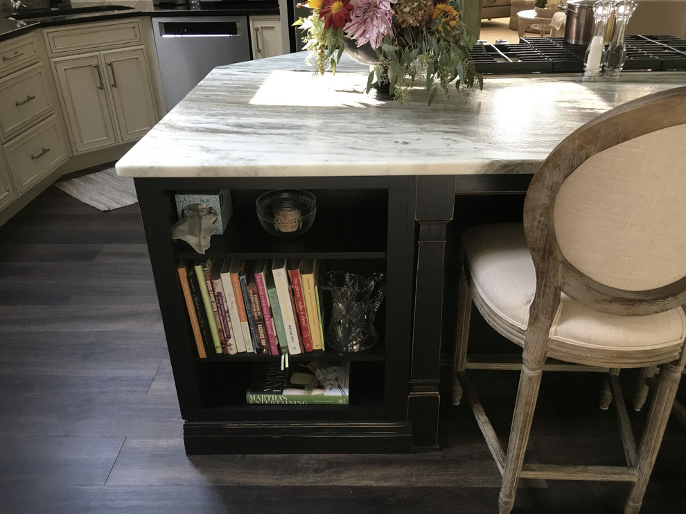 Inspiration for a large transitional u-shaped laminate floor and gray floor eat-in kitchen remodel with an undermount sink, recessed-panel cabinets, white cabinets, granite countertops, white backsplash, ceramic backsplash, stainless steel appliances, an island and black countertops