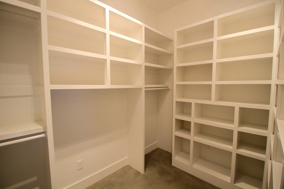 Small modern gender-neutral walk-in wardrobe in Other with open cabinets, white cabinets, concrete floors and grey floor.