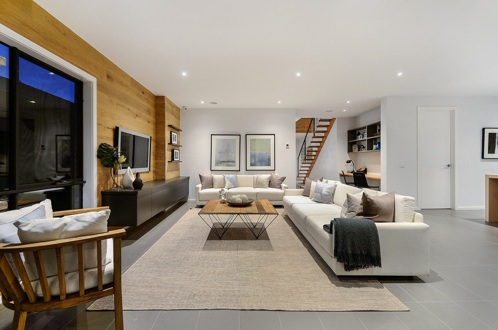 This is an example of a contemporary open concept living room in Melbourne with a wall-mounted tv.