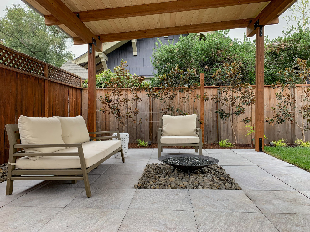Inspiration for a small modern backyard partial sun garden for summer in Portland with natural stone pavers and a wood fence.