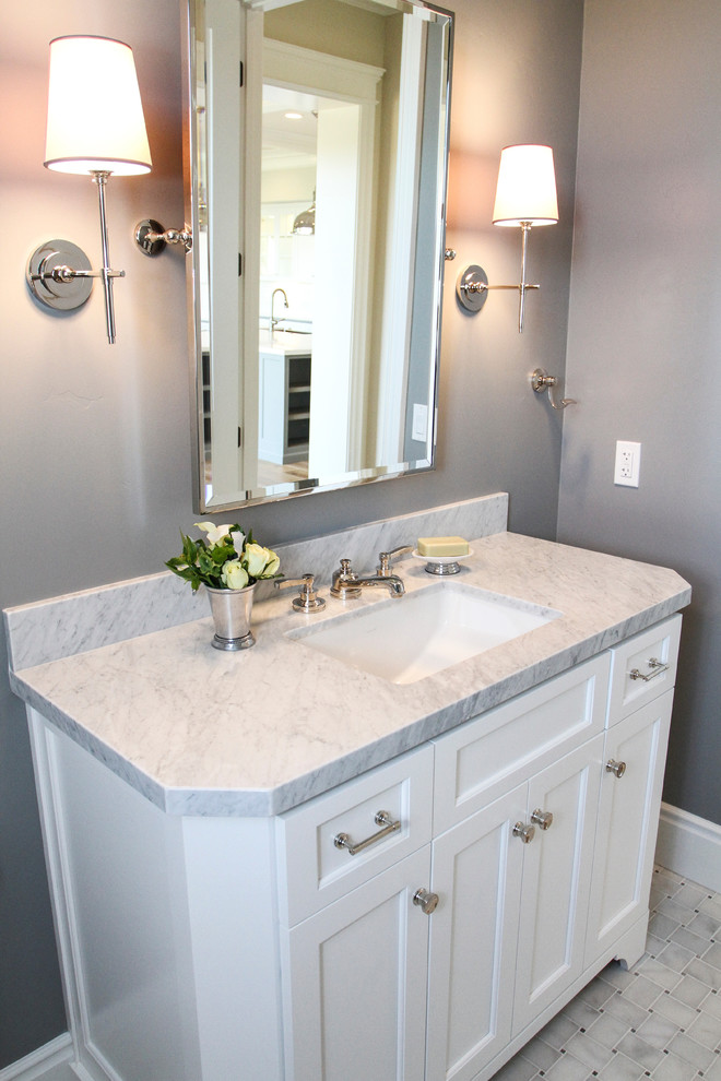 This is an example of a small traditional 3/4 bathroom in San Francisco with an undermount sink, recessed-panel cabinets, white cabinets, marble benchtops, a two-piece toilet, white tile, stone tile, grey walls and marble floors.