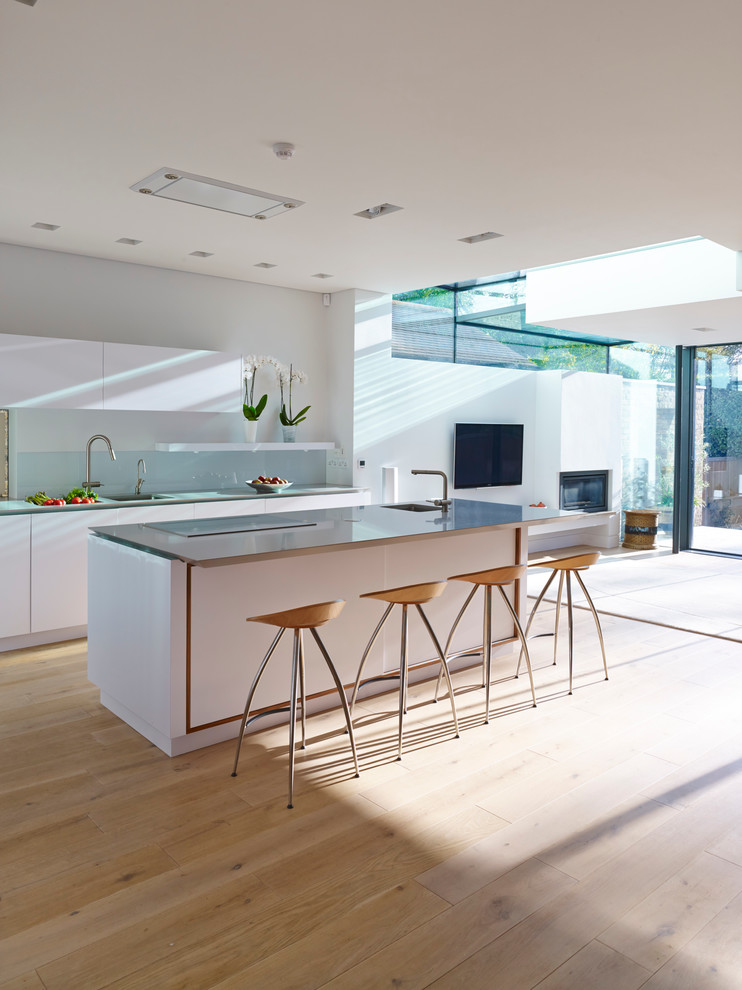 Photo of a large contemporary open plan kitchen in London with flat-panel cabinets, grey cabinets, solid surface benchtops and with island.