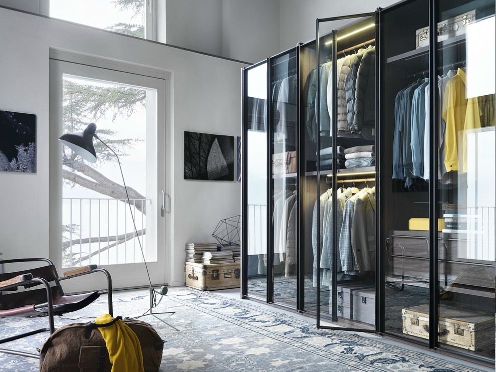Large modern gender-neutral walk-in wardrobe in Catania-Palermo with glass-front cabinets.