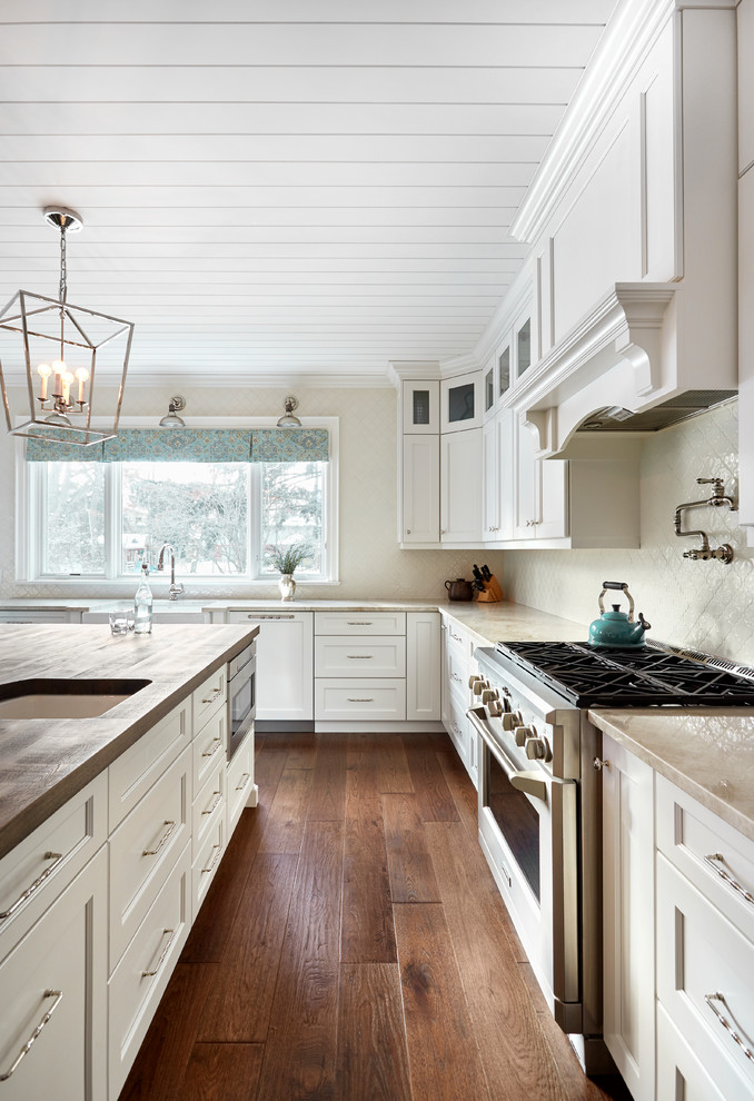 Photo of a country eat-in kitchen in Toronto with a single-bowl sink, recessed-panel cabinets, white cabinets, wood benchtops, ceramic splashback, stainless steel appliances, medium hardwood floors, with island and brown floor.