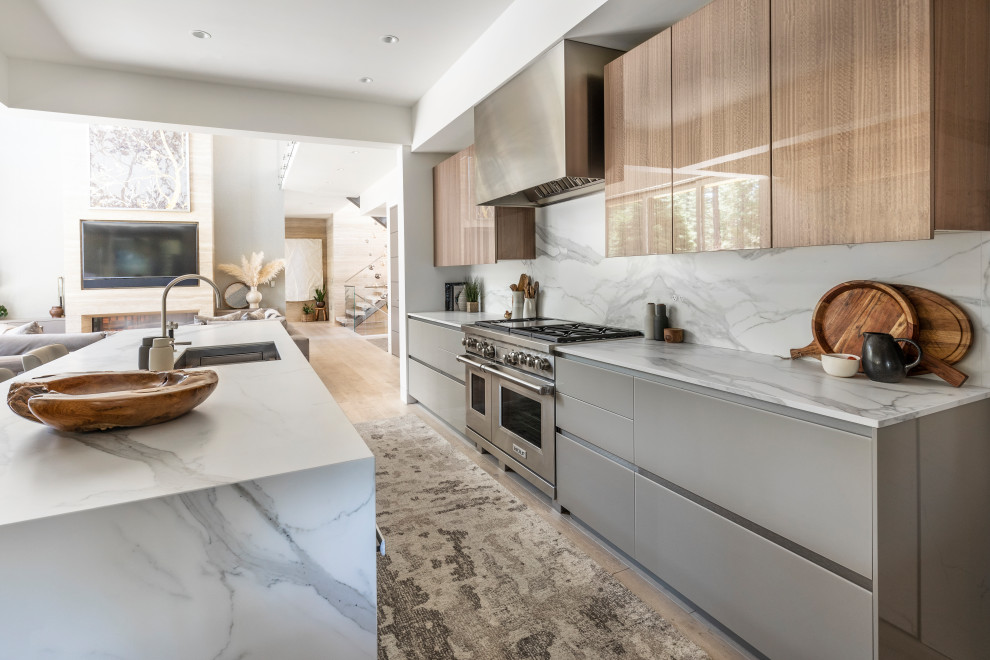 Design ideas for a mid-sized modern eat-in kitchen with a single-bowl sink, glass-front cabinets, brown cabinets, quartz benchtops, multi-coloured splashback, engineered quartz splashback, panelled appliances, light hardwood floors, with island, beige floor and multi-coloured benchtop.