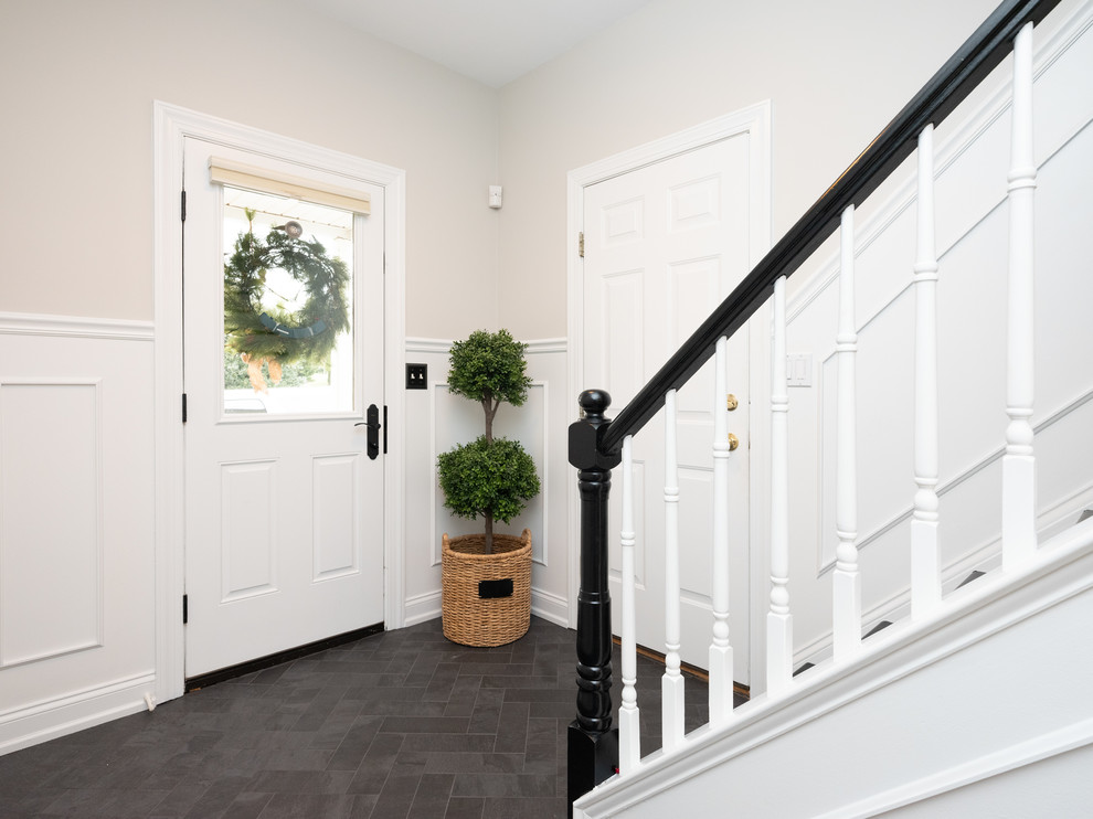 This is an example of a mid-sized transitional mudroom in Philadelphia with grey walls, slate floors, a single front door, a white front door and black floor.