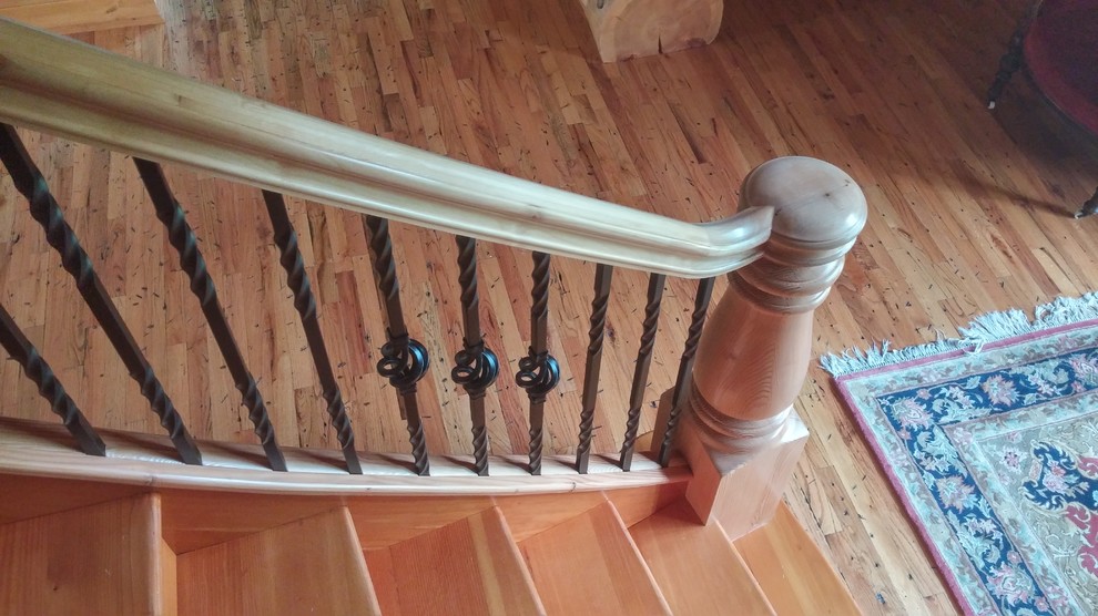 Large mountain style wooden curved staircase photo with wooden risers