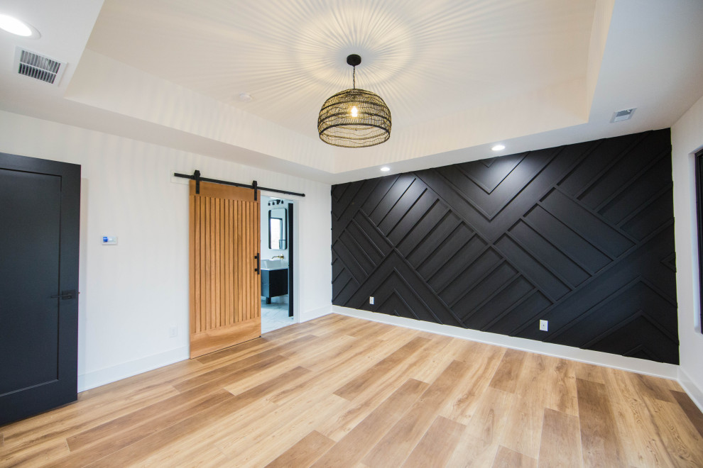 Idée de décoration pour une grande chambre parentale design en bois avec un mur blanc, un sol en bois brun et un sol marron.