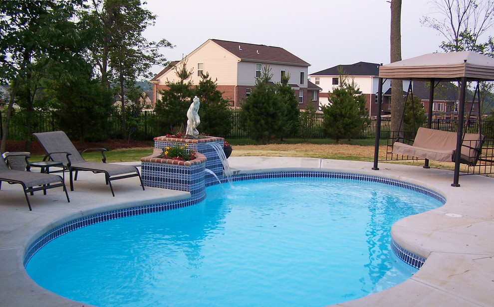 Mid-sized backyard concrete and kidney-shaped natural pool fountain photo in Cincinnati