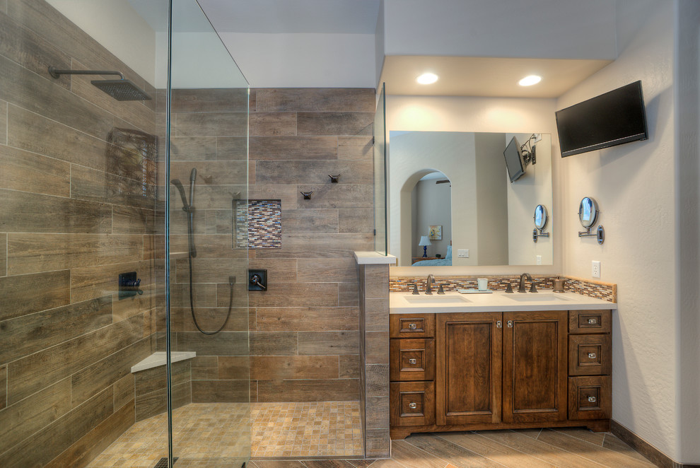 Mid-sized modern master bathroom in Phoenix with recessed-panel cabinets, dark wood cabinets, a freestanding tub, a curbless shower, a two-piece toilet, beige tile, blue tile, brown tile, multi-coloured tile, matchstick tile, beige walls, porcelain floors, an undermount sink and solid surface benchtops.