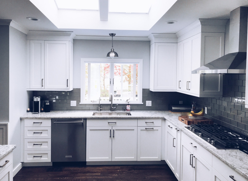Immagine di una cucina classica di medie dimensioni con lavello sottopiano, ante lisce, ante bianche, top in granito, paraspruzzi blu, paraspruzzi con piastrelle di vetro, elettrodomestici in acciaio inossidabile e parquet scuro