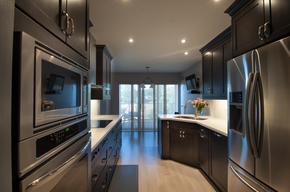Small modern galley eat-in kitchen in Toronto with a double-bowl sink, shaker cabinets, dark wood cabinets, white splashback, subway tile splashback, stainless steel appliances, dark hardwood floors, no island and marble benchtops.