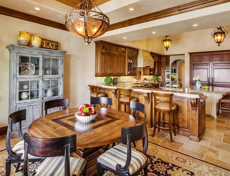 This is an example of a large mediterranean kitchen/dining combo in San Diego with beige walls, limestone floors, no fireplace and brown floor.