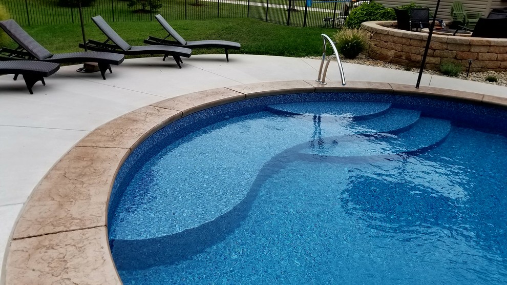 Inspiration for a large traditional backyard custom-shaped pool in St Louis with stamped concrete.