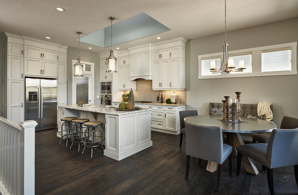 Inspiration for a mid-sized transitional l-shaped dark wood floor open concept kitchen remodel in Calgary with an undermount sink, recessed-panel cabinets, white cabinets, granite countertops, beige backsplash, ceramic backsplash, stainless steel appliances and an island