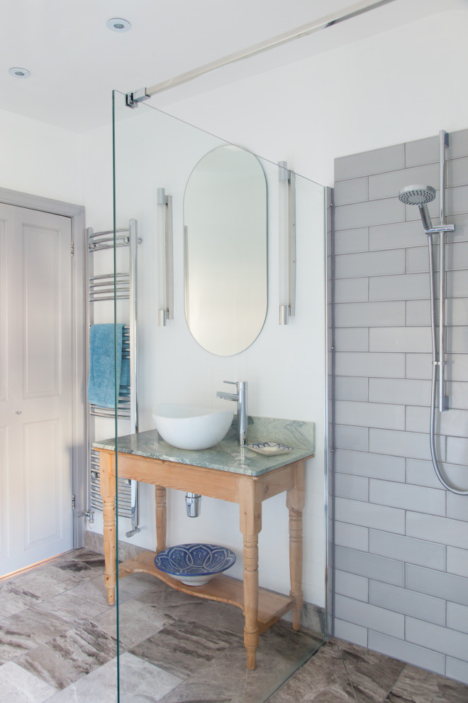 This is an example of a mid-sized transitional 3/4 bathroom in Sussex with a corner shower, gray tile, porcelain tile, white walls, porcelain floors, a vessel sink, grey floor, an open shower, green benchtops, a single vanity and a freestanding vanity.