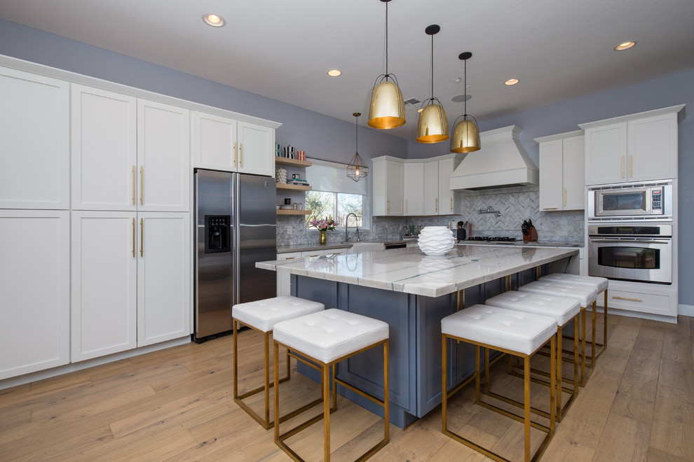 Inspiration for a large contemporary l-shaped eat-in kitchen in Phoenix with a farmhouse sink, shaker cabinets, yellow cabinets, quartzite benchtops, grey splashback, marble splashback, stainless steel appliances, light hardwood floors, with island and multi-coloured floor.