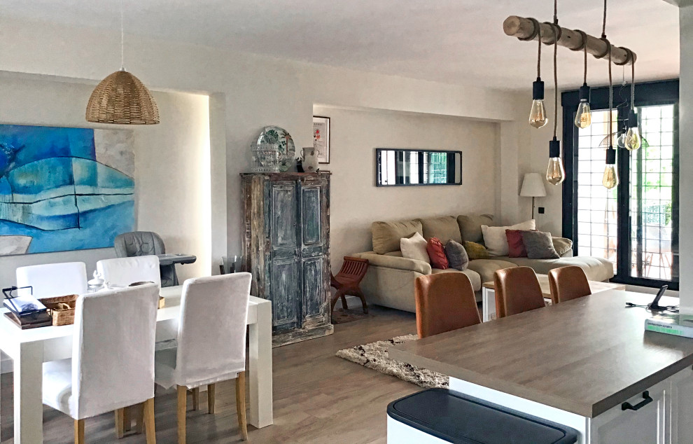 Immagine di una grande sala da pranzo aperta verso la cucina design con pareti bianche, pavimento in laminato e pavimento beige