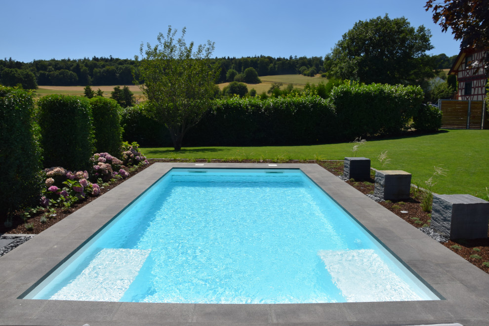 Mittelgroßer Moderner Pool neben dem Haus in rechteckiger Form mit Natursteinplatten in Frankfurt am Main