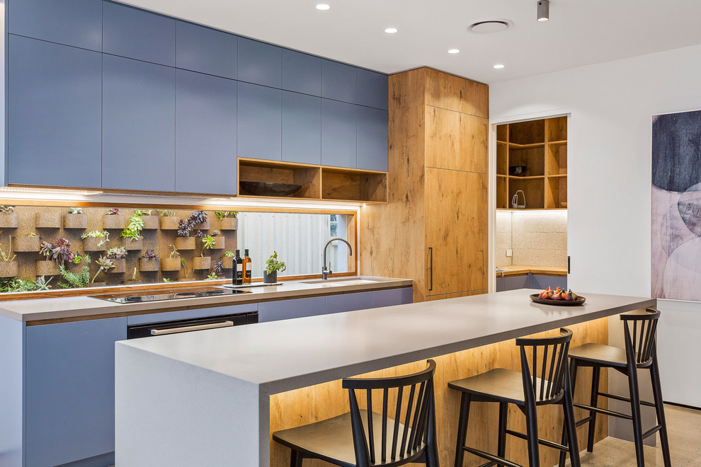 Mid-sized contemporary galley eat-in kitchen in Melbourne with an undermount sink, medium wood cabinets, concrete benchtops, window splashback, concrete floors, with island, grey floor, grey benchtop and flat-panel cabinets.