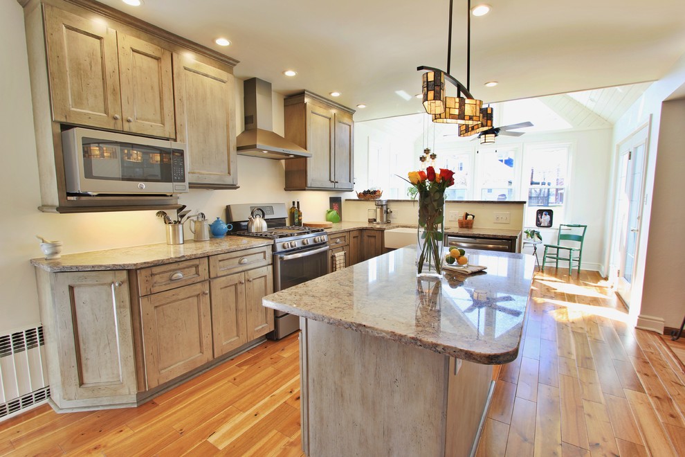 Photo of a mid-sized eat-in kitchen in Other with a farmhouse sink, distressed cabinets, granite benchtops, stainless steel appliances, light hardwood floors and with island.