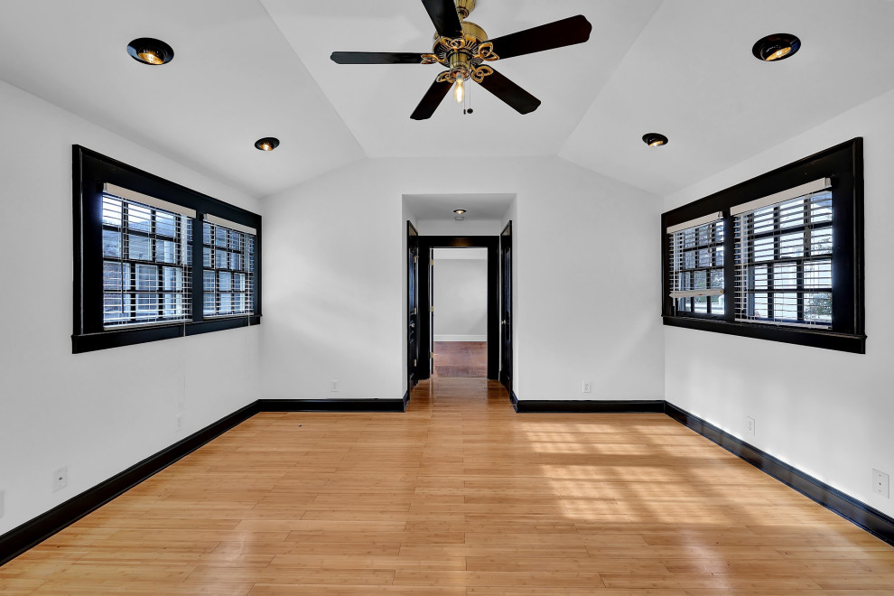 Example of a large mid-century modern bamboo floor, yellow floor and vaulted ceiling home yoga studio design in Atlanta with white walls