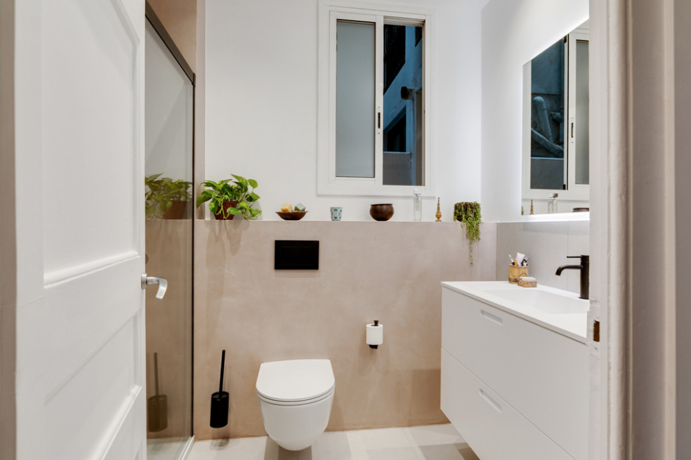 Modern inredning av ett litet en-suite badrum, med möbel-liknande, bruna skåp, en kantlös dusch, en vägghängd toalettstol och dusch med skjutdörr