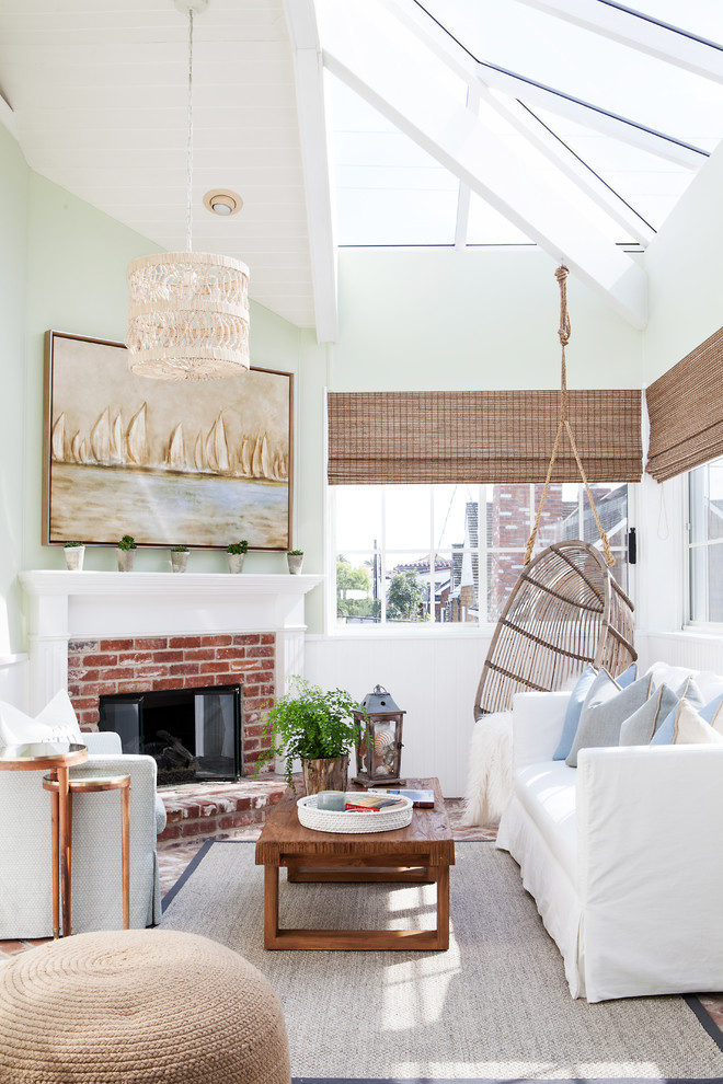 Example of a beach style sunroom design in Orange County with a standard fireplace, a brick fireplace and a glass ceiling
