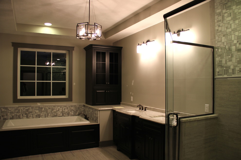 Inspiration for a large rustic master multicolored tile and ceramic tile cement tile floor and gray floor drop-in bathtub remodel with glass-front cabinets, black cabinets, a two-piece toilet, beige walls, an undermount sink, granite countertops and a hinged shower door