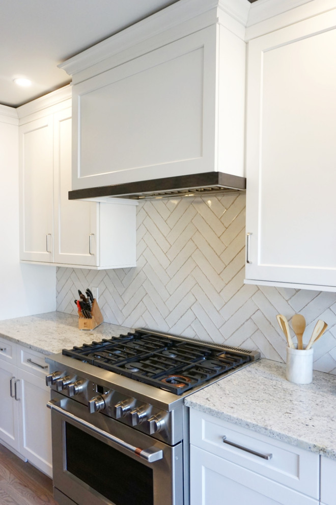 Eat-in kitchen - huge transitional light wood floor and brown floor eat-in kitchen idea with an undermount sink, shaker cabinets, white cabinets, granite countertops, white backsplash, ceramic backsplash, stainless steel appliances, an island and white countertops