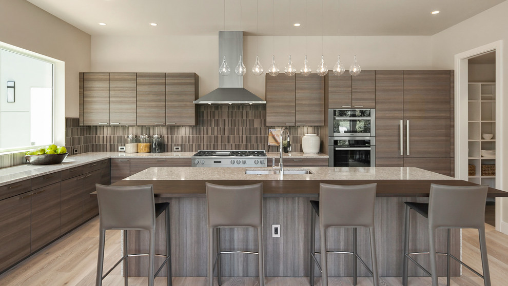 This is an example of a contemporary l-shaped kitchen in Seattle with an undermount sink, flat-panel cabinets, dark wood cabinets, brown splashback, stainless steel appliances, light hardwood floors, with island and beige floor.