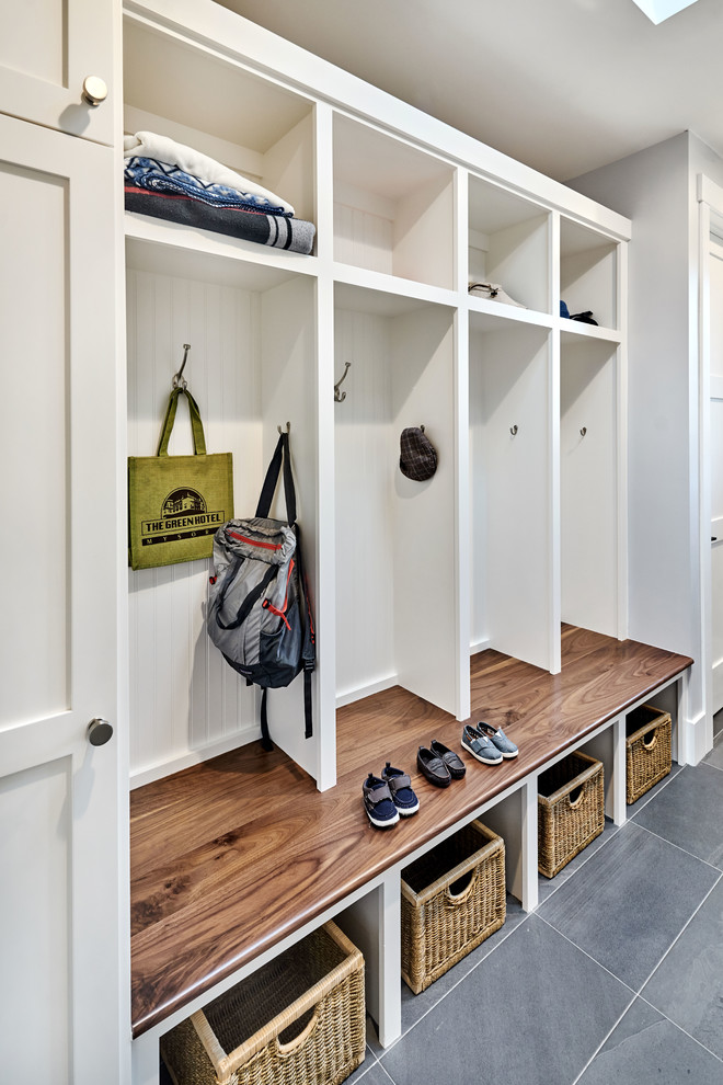 This is an example of a mid-sized transitional galley utility room in San Francisco with an utility sink, shaker cabinets, white cabinets, quartz benchtops, grey walls, porcelain floors and a side-by-side washer and dryer.
