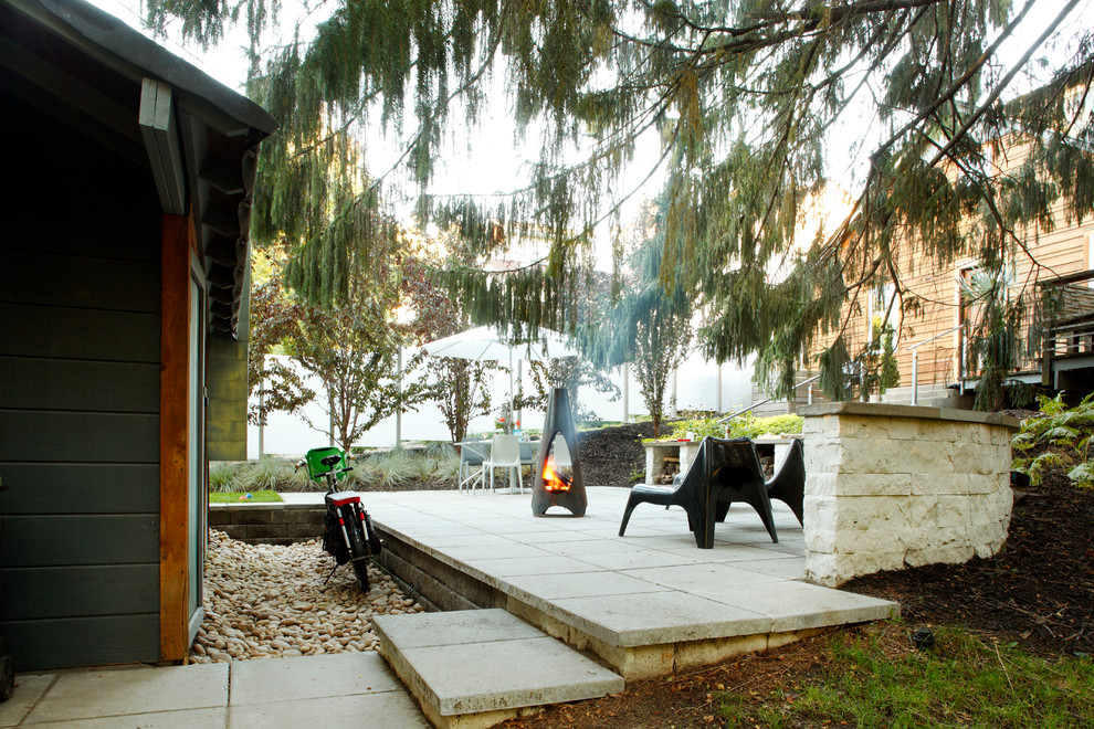 This is an example of a contemporary backyard patio in Minneapolis with a fire feature, concrete pavers and no cover.