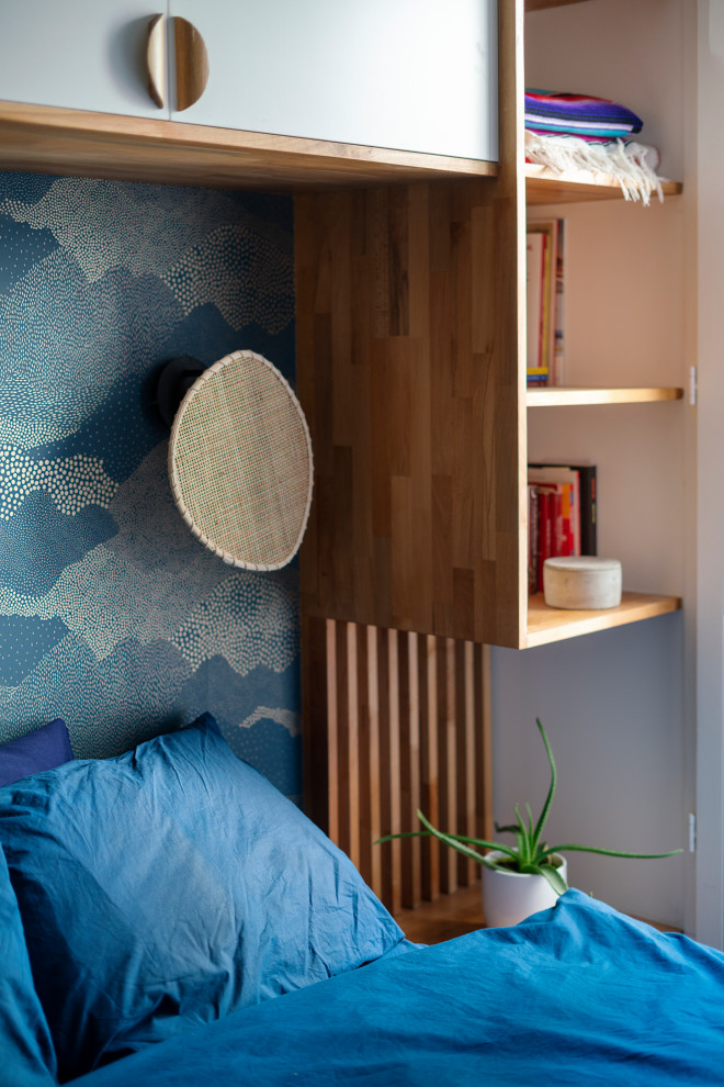Ejemplo de dormitorio principal escandinavo pequeño sin chimenea con paredes blancas, suelo de madera clara, suelo gris y papel pintado