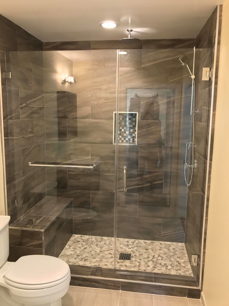 Inspiration for a large modern master bathroom in Los Angeles with open cabinets, dark wood cabinets, a double shower, a two-piece toilet, gray tile, ceramic tile, yellow walls, porcelain floors, a wall-mount sink, solid surface benchtops, a hinged shower door, beige floor and white benchtops.