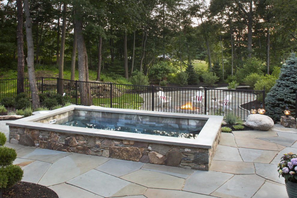 This is an example of a small traditional backyard rectangular natural pool in Portland Maine with a hot tub and natural stone pavers.