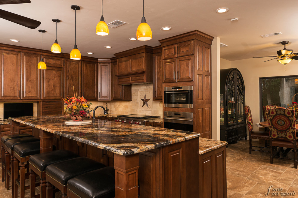 Design ideas for a mid-sized traditional galley eat-in kitchen in Dallas with an undermount sink, raised-panel cabinets, dark wood cabinets, granite benchtops, beige splashback, ceramic splashback, stainless steel appliances, travertine floors and with island.