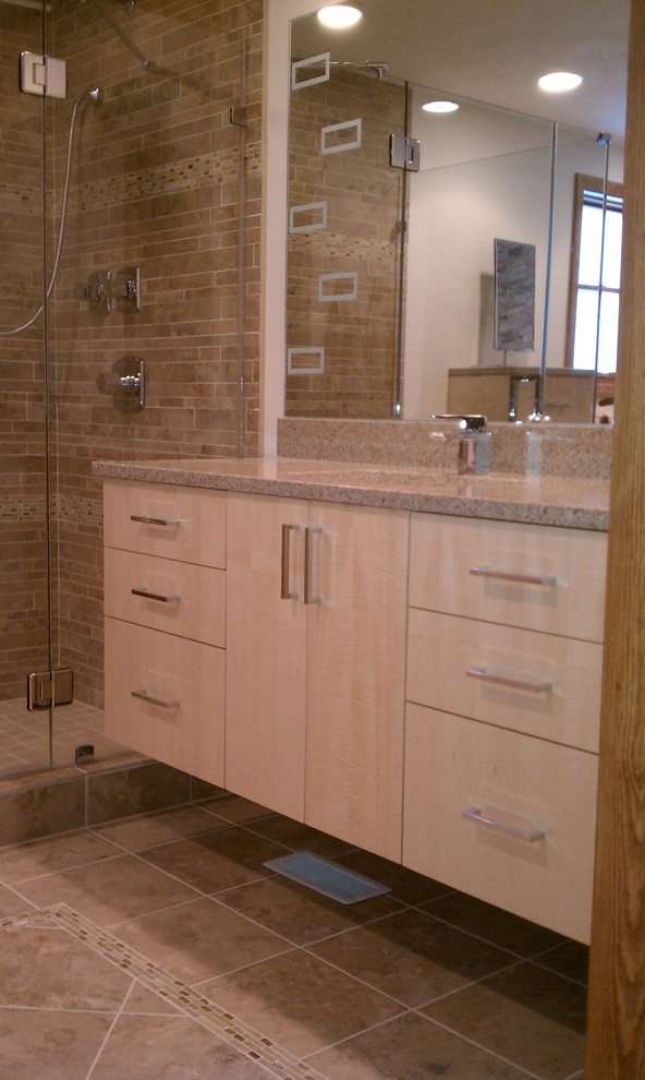 Inspiration for a mid-sized contemporary 3/4 bathroom in Cleveland with an undermount sink, flat-panel cabinets, light wood cabinets, granite benchtops, a corner shower, beige tile and brown walls.