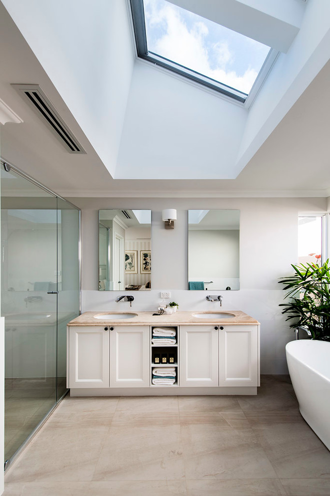 Photo of a transitional bathroom in Perth with an undermount sink, recessed-panel cabinets, white cabinets, a freestanding tub, an alcove shower and grey walls.