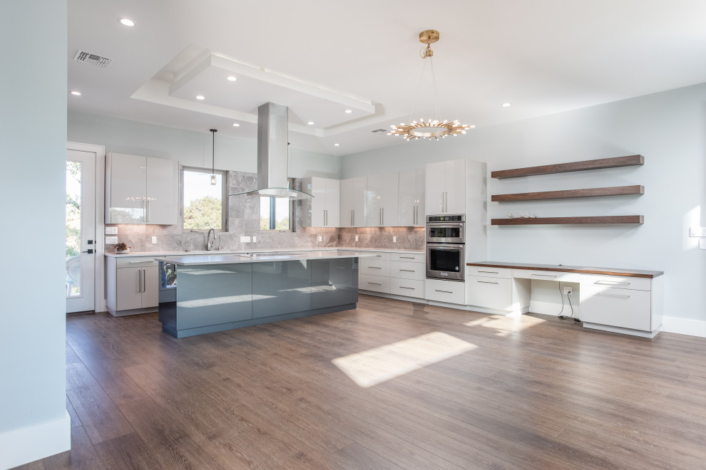 Inspiration for a large contemporary u-shaped open plan kitchen in Austin with an undermount sink, flat-panel cabinets, grey cabinets, solid surface benchtops, grey splashback, porcelain splashback, stainless steel appliances, vinyl floors, with island, brown floor, grey benchtop and coffered.