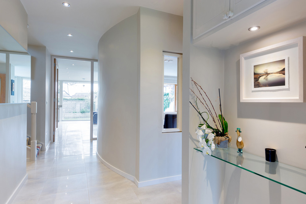 This is an example of a large contemporary hallway in Dublin with grey walls and porcelain floors.