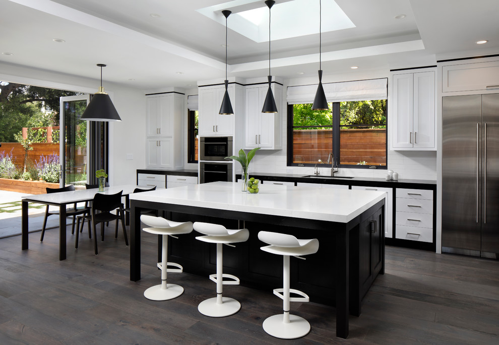 Design ideas for a large contemporary single-wall eat-in kitchen in San Francisco with an undermount sink, shaker cabinets, white splashback, subway tile splashback, stainless steel appliances, with island, quartz benchtops, dark hardwood floors and grey floor.