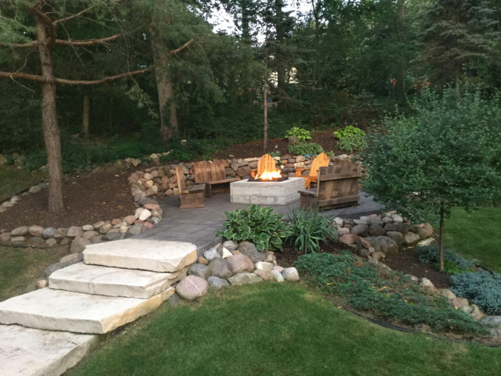 Photo of a large traditional backyard patio in Milwaukee with a fire feature and no cover.